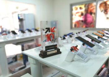 Vue intérieure de l’agence Glotelho de Drouot à Akwa, avec des smartphones exposés sur des présentoirs et un trophée commémorant les 10 ans de l’entreprise.
