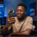 Jeune homme africain utilisant un Nothing Phone (4a) dans un environnement high-tech moderne, avec éclairage cinématique et design transparent caractéristique du smartphone.