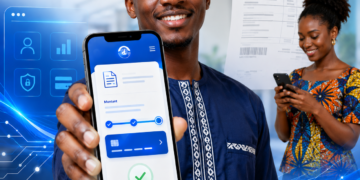eBill fait peau neuve : au-delà du design, CAMTEL joue sa crédibilité numérique 1 Jeune homme africain présentant un smartphone affichant une interface de paiement numérique inspirée d'eBill de CAMTEL, tandis qu'une femme consulte son téléphone en arrière-plan dans un environnement technologique moderne.