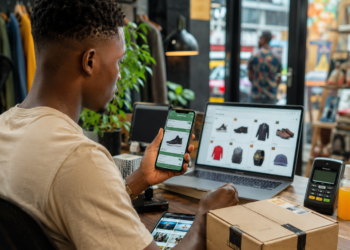 Jeune Camerounais réalisant des achats en ligne via smartphone, illustrant l'essor du e-commerce, de WhatsApp et du Mobile Money au Cameroun.