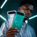 Jeune homme africain présentant deux TECNO CAMON Slim avec module photo arrière et mini-LED