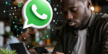 Un jeune Africain utilise WhatsApp sur son smartphone, illustrant l'arrivée des noms d'utilisateur permettant de communiquer sans partager son numéro de téléphone.