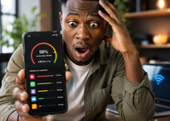 Jeune homme africain surpris en découvrant la forte consommation de données mobiles sur son smartphone