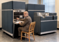 Jacques Perret assis devant un ordinateur IBM 650 dans une salle informatique des années 1950