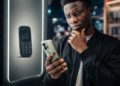 itel : son image de marque est-elle devenue son plus grand défi ? 63 Un consommateur africain hésite devant un smartphone itel moderne