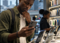 Smartphones : pourquoi les prix flambent au Cameroun ? 63 Un jeune Africain compare un smartphone dans une boutique alors que les prix augmentent au Cameroun en 2026.