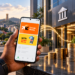 Un utilisateur consulte Orange Money et MTN Mobile Money sur un smartphone devant une banque, avec des piles de pièces illustrant les intérêts bancaires générés par les fonds cantonnés au Cameroun.